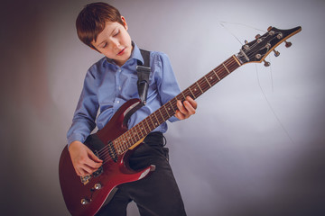 teenager boy of 10 years European appearance rejoices plays g