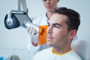 Serious young man undergoing dental checkup