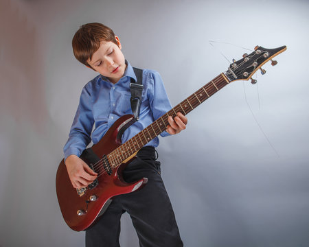 teenager boy of 10 years European appearance rejoices plays g
