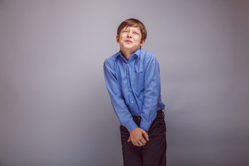 teenager boy wants to use the toilet on gray background