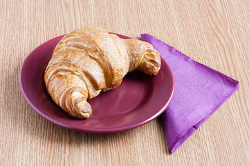 coissant on a plate and napkin