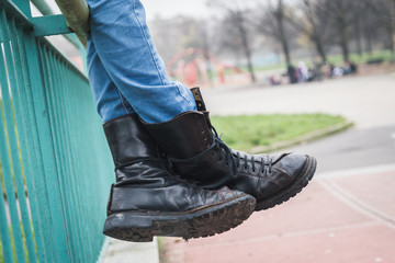 Detail of black boots in a city park