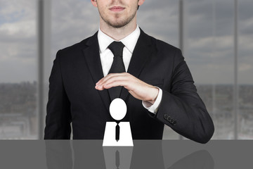businessman holding protective hand above employee