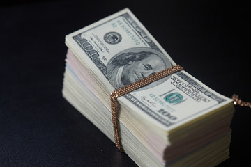 a bundle of money tied with gold chain