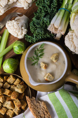 Creamy cauliflower soup in rustic ceramic bowl from above