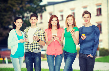 Obraz premium smiling students with smartphones