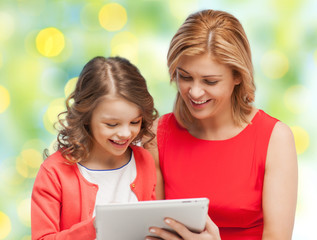 mother and daughter with tablet pc over green