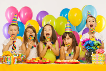 Group of joyful little kids having fun at birthday party