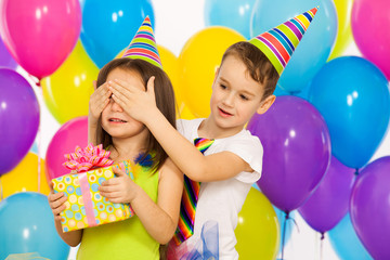 Joyful little kid girl receiving gifts at birthday party