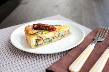 Piece of pie with spinach and fish salmon