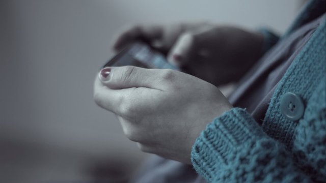 Closeup of young woman hands typing sms scrolling pictures phone
