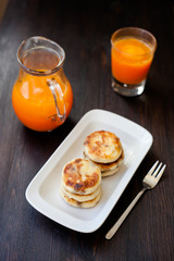 Delicious homemade cheese pancakes with fresh carrot juice
