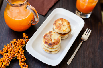 Delicious homemade cheese pancakes with fresh carrot juice