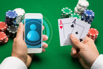 casino player with cards, smartphone and chips