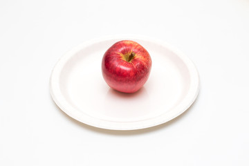 One red apple in a plate on white