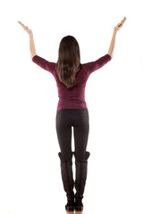 Back view of a young woman with hands raised on white