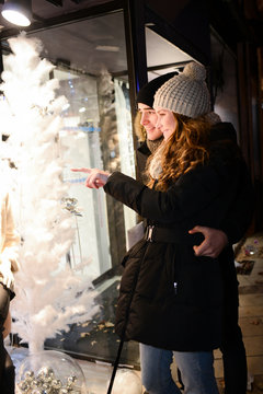 cheerful young couple doing winter shopping at night