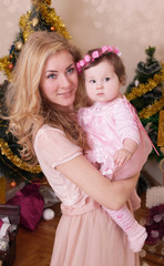 Mother hugging baby girl dressed like angel