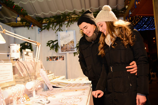 cheerful young couple doing winter shopping at night