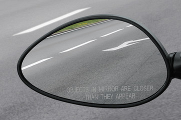 Rear view mirror with warning text objects in mirror are closer