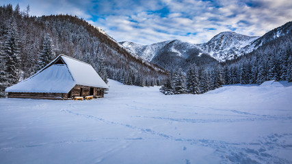 Old cottage in winter mountains