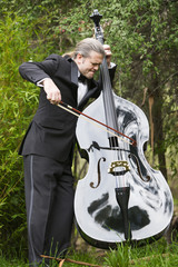 man playing the double bass in park