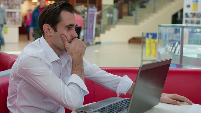Stressed businessman working with his laptop at table in patio