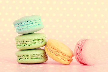 Tasty macaroons on pink polka dot background
