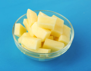Raw peeled and chopped potatoes in glass bowl