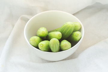 fresh green cucumbers on white fabric background