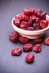 dried cranberries in a wooden spoon.fruit full of vitamin c. 