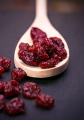 dried cranberries in a wooden spoon.fruit full of vitamin c. 