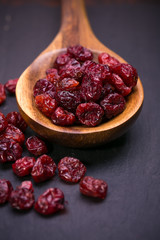 dried cranberries in a wooden spoon.fruit full of vitamin c. 