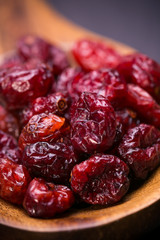 dried cranberries in a wooden spoon.fruit full of vitamin c. 