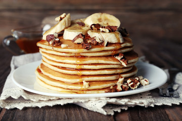 Stack of delicious pancakes with chocolate, honey, nuts and