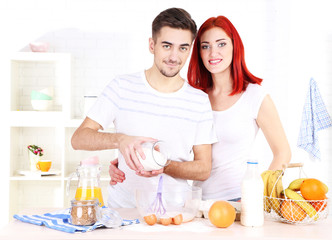 Obraz na płótnie Canvas Happy couple preparing dough baking in kitchen