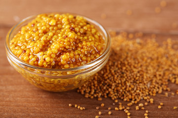 Mustard in bowl on wooden background