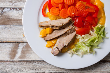 Duck meat slices with orange and vegetables, closeup