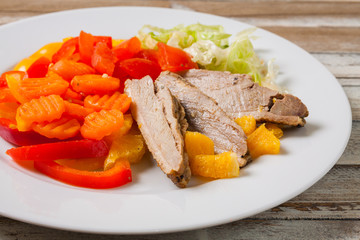 Roast duck breast with orange and vegetables, closeup