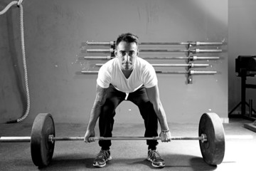 Fototapeta na wymiar young man on a weightlifting session - crossfit workout.