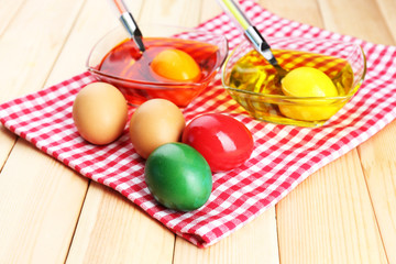 Bowls with paint for Easter eggs and eggs, close up
