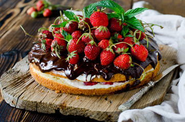 Sponge cake with cream, strawberries and chocolate