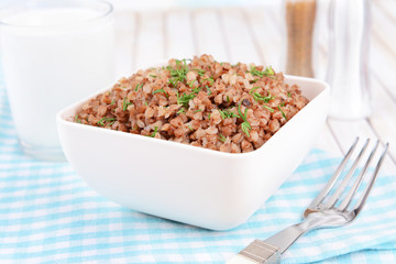Boiled buckwheat in bowl on table close-up