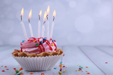 Birthday cup cake with candles and sparkles