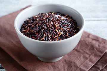 Raw black rice in a clay bowl
