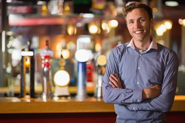 Handsome young man smiling with arms crossed