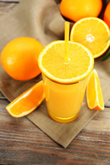 Glass of orange juice with straw and slices