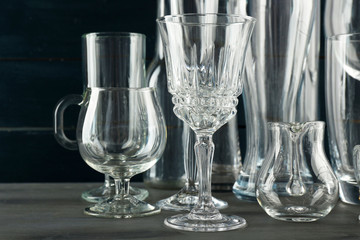 Different glassware on dark color wooden background