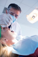 Fototapeta premium Dentist examining a patients teeth under bright light