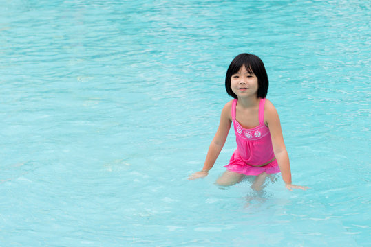 Little Asian girl in swimming pool